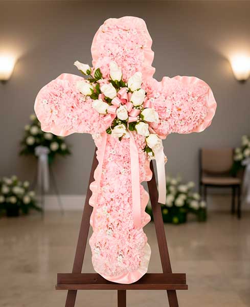 Cruz de flores de tonos rosas